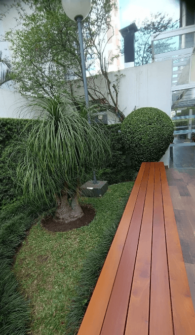 Jardim bem cuidado ao lado de banco de madeira